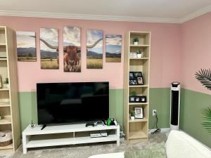 a living room with a flat screen tv at Stylish Studio with Kitchenette in Sterling +14 photos