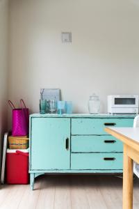 a blue dresser in a room with a table at Machicanty -まちかんてぃ- in Motobu