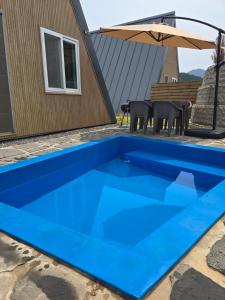 una piscina blu davanti a una casa di Danyang Semo House a Danyang