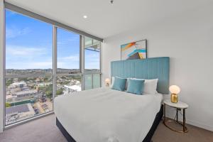 a bedroom with a large bed and large windows at Trafalgar Lane Apartments by CLLIX in Brisbane