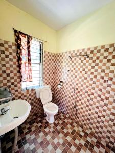 a bathroom with a toilet and a sink at Chitwan Safari Resort in Sauraha