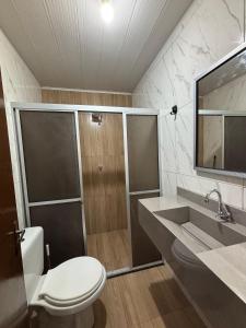 a bathroom with a toilet and a sink and a shower at Kitnet Perto de Tudo-Varanda-Garagem in Feira de Santana