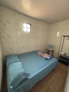 a bedroom with a blue bed in a room at Kitnet Perto de Tudo-Varanda-Garagem in Feira de Santana