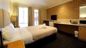 ein Hotelzimmer mit einem Bett und einem Schreibtisch in der Unterkunft Alexandra Place in Bendigo