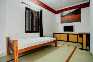 Un dormitorio con una cama y un televisor. en Hotel O Premier Park, en Trivandrum