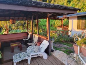 a wooden deck with a bench and a piano at Fare Bungalow in Papeete
