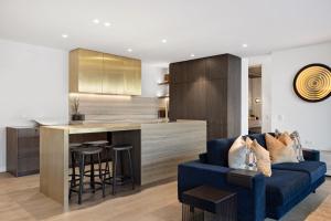 salon z niebieską kanapą i kuchnią w obiekcie The Bunkers Penthouse-2 Bed w mieście Queenstown