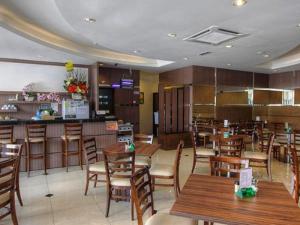 a restaurant with wooden tables and chairs and a bar at Country Hotel in Klang