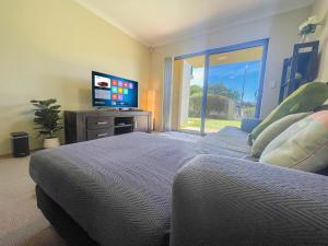 a bedroom with two beds and a flat screen tv at Ground Garden-Two King Beds&One Queen Bed in Perth