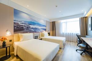 a hotel room with two beds and a desk at Atour Hotel (Suzhou Wujiang Fenxi) in Suzhou