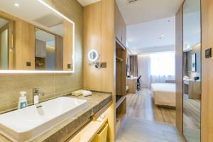 a bathroom with a sink and a mirror at Atour Hotel (Suzhou Wujiang Fenxi) in Suzhou