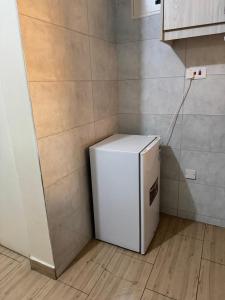 a white refrigerator in a kitchen with a wall at The Skyline Loft in Juja +13 photos