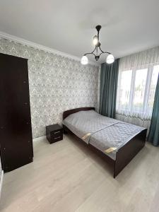 a bedroom with a bed and a chandelier at Ne Dacha in Karakol