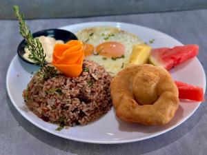 a white plate of food with rice and a donut at Apto aire acondicionado 100 m de la playa bicicletas gratis in Puerto Viejo