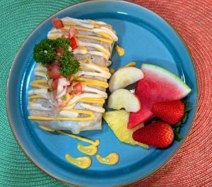a blue plate with sandwiches and fruit on a table at Apto aire acondicionado 100 m de la playa bicicletas gratis in Puerto Viejo