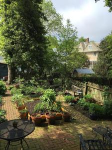 a garden with potted plants and a table and chairs at 1879 Downtown Annapolis Home with Koi Ponds and Gardens in Annapolis