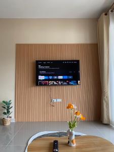 a television on a wall in a room with a table at FUJI Hotel in Nakhon Ratchasima