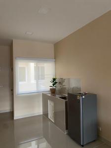 a kitchen with a stainless steel refrigerator and a window at FUJI Hotel in Nakhon Ratchasima
