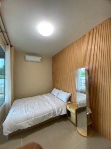 a small bedroom with a bed and a window at FUJI Hotel in Nakhon Ratchasima