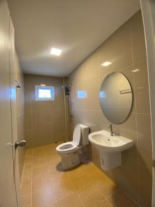 a bathroom with a toilet and a sink and a mirror at FUJI Hotel in Nakhon Ratchasima +5 photos