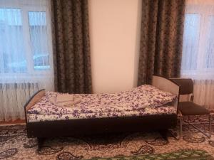 a small bed in a room with curtains at Kyrgyz Family in Bokonbayevo +8 photos