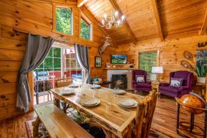 een eetkamer met een houten tafel in een hut bij Peaceful Pines Cabin-patio with hot tub for small families or couples in Gatlinburg