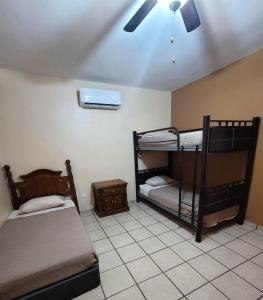 two bunk beds in a room with a ceiling fan at Casa céntrica--zona vado del rio in Hermosillo