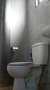a bathroom with a white toilet in a room at บ้านพักคุณยายเขียว in Ban Thung Kham +9 photos