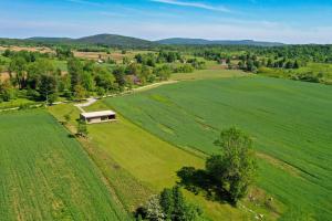 an aerial view of a large green field with a house at Cube Hills in Rakovica