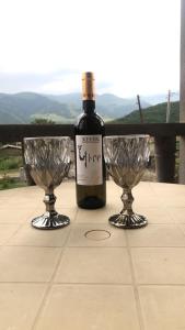 eine Flasche Wein und zwei Weingläser auf einem Tisch in der Unterkunft Zartonq in Tatev