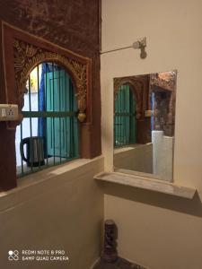 un espejo en una pared junto a una ventana en Hotel The Shanggri-La Heritage, en Jodhpur