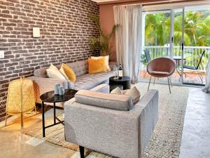 un salon avec un canapé et un mur de briques dans l'établissement Burleigh Heads Koala Park Pool & Parking, à Gold Coast 17 autres photos