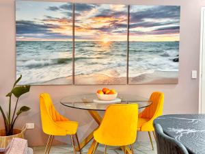 une salle à manger avec quatre tableaux de l'océan dans l'établissement Burleigh Heads Koala Park Pool & Parking, à Gold Coast