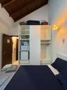 a bedroom with a bed and a white cabinet at suite ao som do mar - tombo guaruja in Guarujá