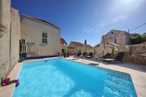 a large blue swimming pool next to a building at Vacation House Meri in Blato