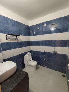 巴特那Hotel Siddhi Residency的蓝白色浴室，配有马桶和水槽