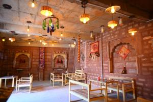 Un restaurante con mesas y sillas en una sala. en Hotel The Shanggri-La Heritage, en Jodhpur