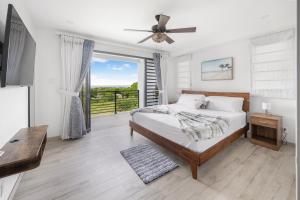 une chambre avec un lit avec un ventilateur de plafond dans l'établissement the views by DanTopia villa, à Saint James 26 autres photos