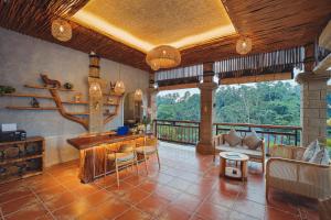 a living room with a couch and a table at Harsa Sanctuary by GenuineHost in Ubud