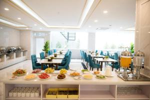 ein Restaurant mit Tellern voller Essen auf einem Tisch in der Unterkunft Urbanite Hotel in Vientiane