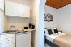a kitchen with a bed and a sink in a room at Theklas Studios Sea View in Agios Georgios Pagon