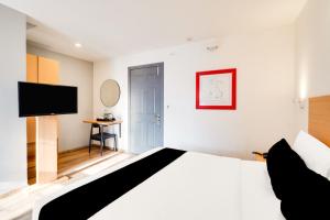 a bedroom with a bed and a flat screen tv at Super Townhouse BTM Layout Near Madiwala Lake Formerly Q Rooms in Bengaluru +24 photos