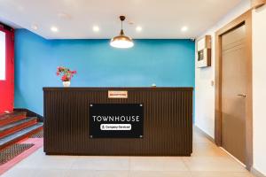 a front desk of a town house with a blue wall at Super Townhouse BTM Layout Near Madiwala Lake Formerly Q Rooms in Bangalore