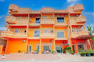a large orange building with a lot of windows at Hotel O Kuta Alam Near Masjid Oman Al-Makmur Formerly Daka Hotel in Lheue