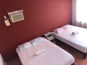 1 Schlafzimmer mit 2 Betten, einem Fenster und einem Stuhl in der Unterkunft Hotel Las Flores in Acapulco