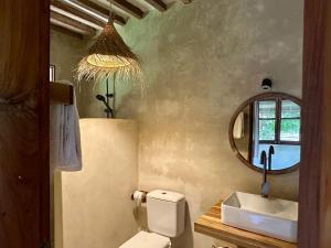 ein Badezimmer mit Toilette, Waschbecken und Spiegel in der Unterkunft Maisha Nungwi - Boutique Hotel in Nungwi + 37 Fotos