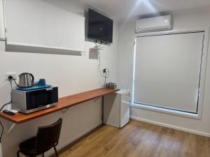 a kitchen with a counter with a microwave and a window at Blackbutt Motel in Blackbutt