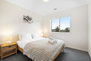 a bedroom with a bed with a teddy bear on it at Stylish & Simple 3BR Mount Duneed Home in Mount Duneed