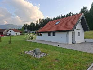 a white house with a red roof in a yard at Sun House Luka in Radmirje