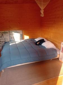 a large bed in a room with a wooden wall at Tiny House Eurovelo 6 in Chalon-sur-Saône